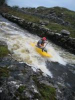 Photo of the Dunkellin river in County Galway Ireland. Pictures of Irish whitewater kayaking and canoeing. Rob yeomans on the wave at the first wave train.